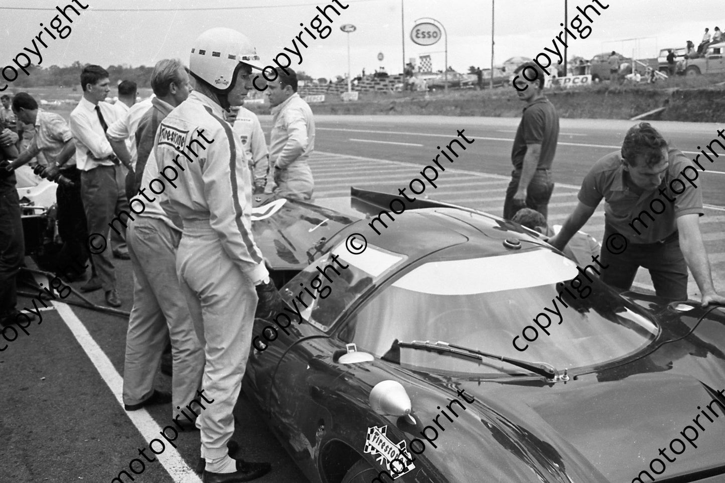 1967 3 John Love, Paul Hawkins behind hands on hips, Lola Chev T70 (courtesy Ken Stewart) 300